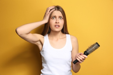 Photo of Young woman with hair loss problem on color background