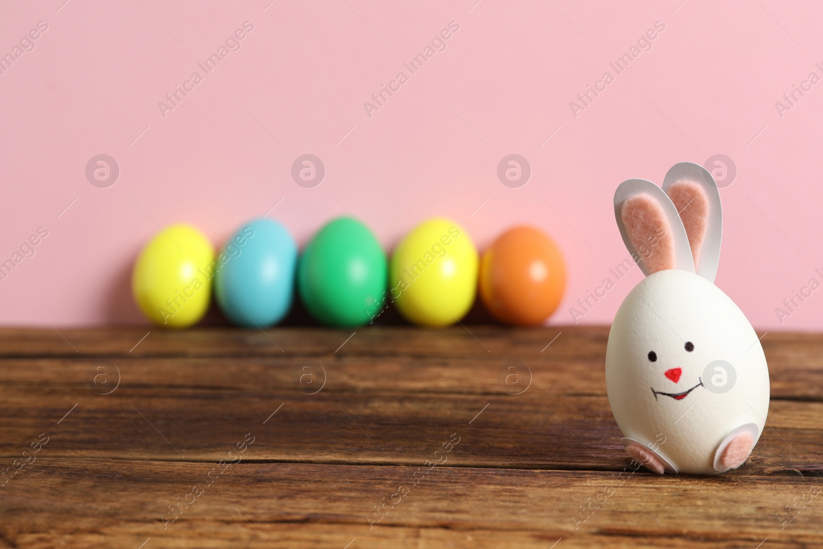 Photo of Egg as cute bunny on wooden table, space for text. Easter celebration
