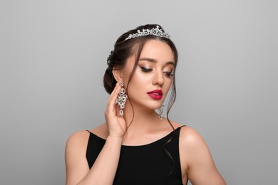 Photo of Beautiful young woman wearing luxurious tiara on light grey background