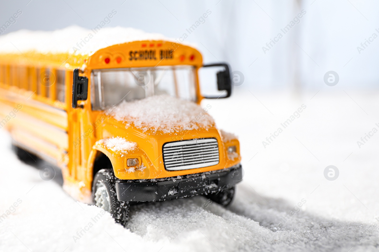 Photo of Yellow school bus on snowy road, closeup. Transport for students