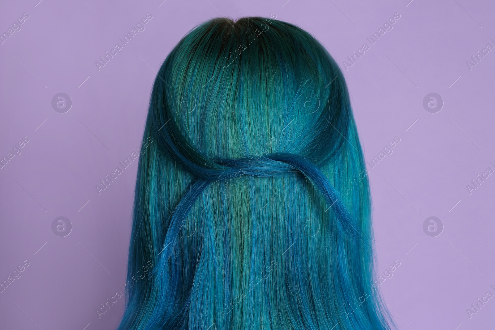 Photo of Woman with bright dyed hair on lilac background, back view