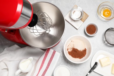 Red stand mixer and different ingredients on light grey marble table, flat lay