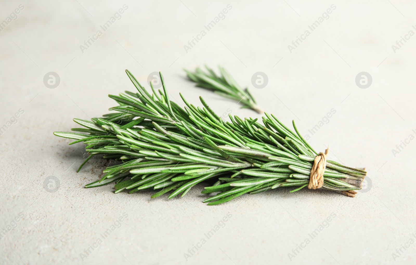 Photo of Bunch of fresh green rosemary on light table