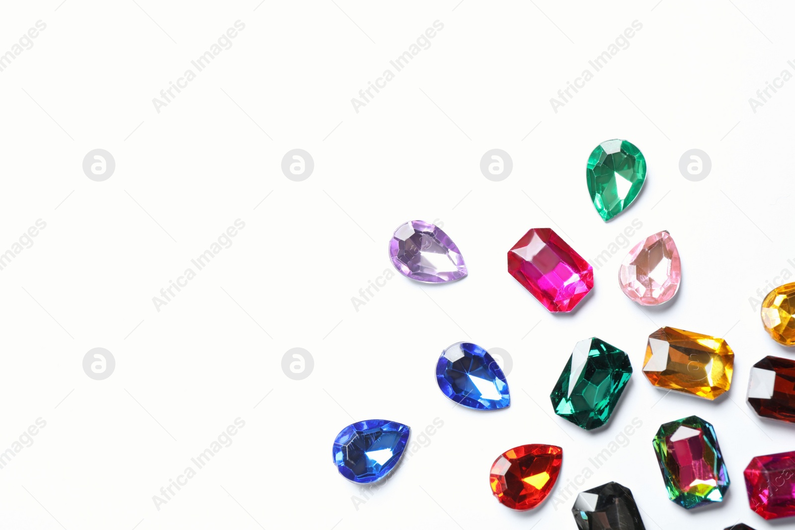 Photo of Different beautiful gemstones on white background, top view