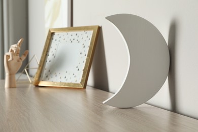 Photo of Crescent shaped night lamp on wooden shelf in child's room