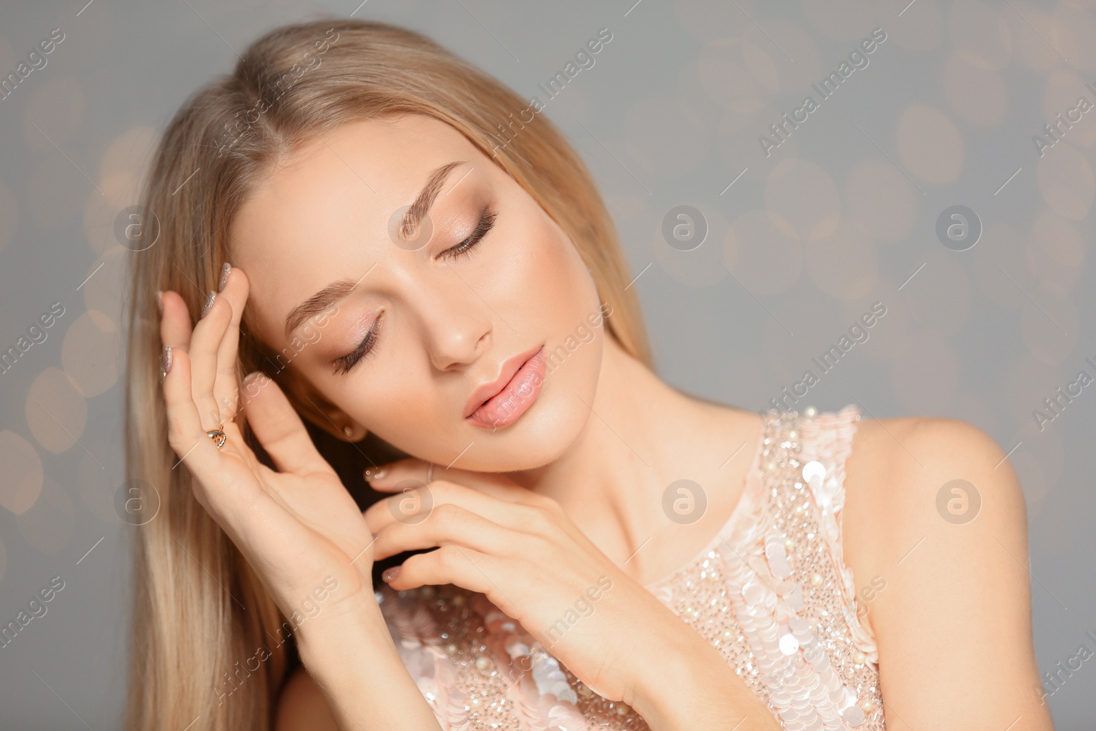 Photo of Portrait of beautiful young woman with shiny manicure on blurred background. Nail polish trends