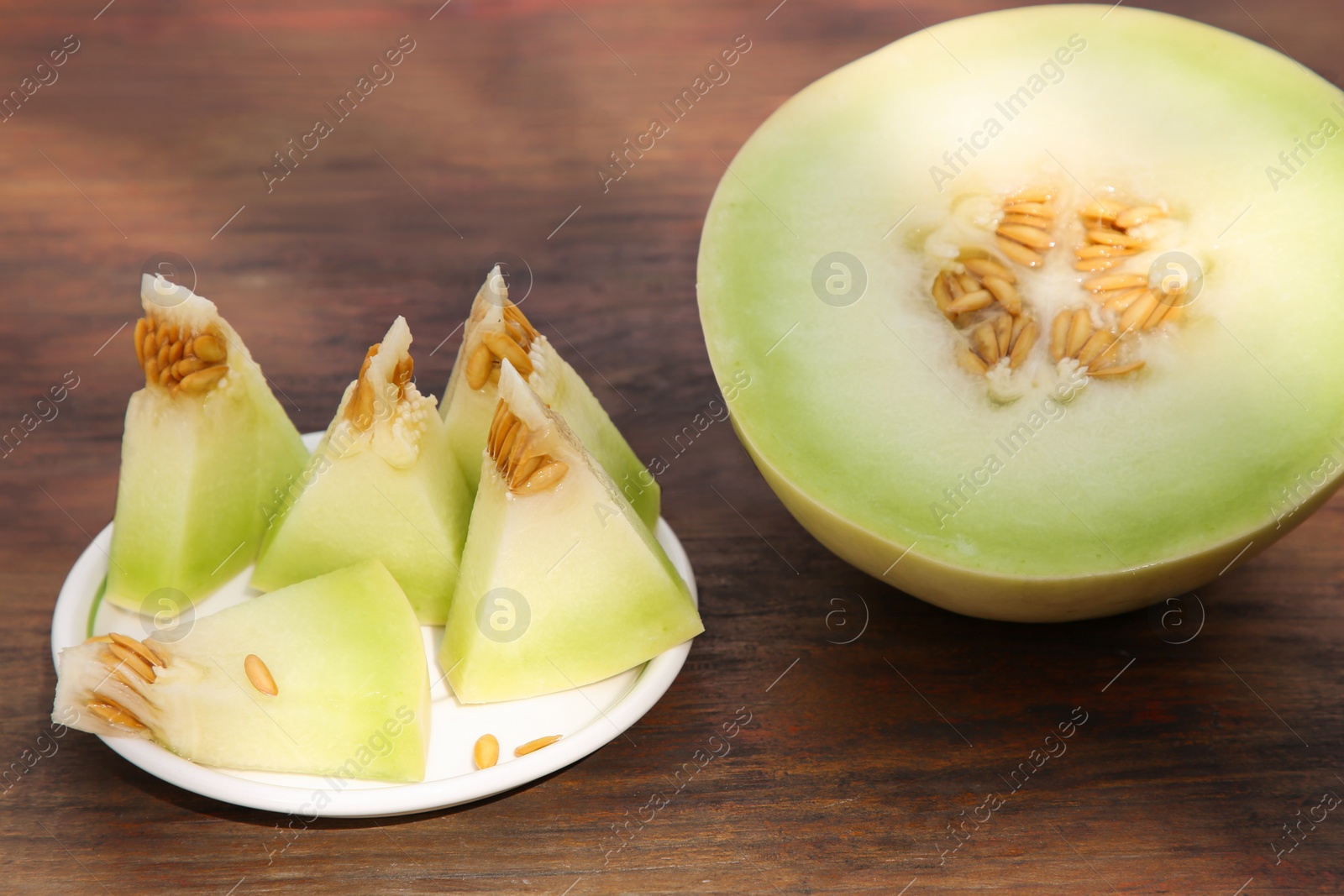 Photo of Cut tasty ripe melon on wooden table