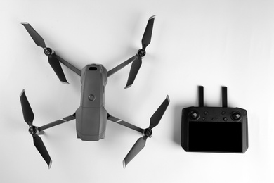 Modern drone with controller on white background, top view