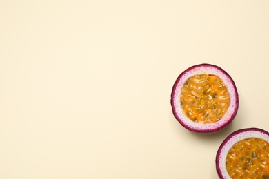 Photo of Halves of fresh ripe passion fruit (maracuya) on beige background, flat lay. Space for text