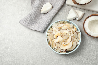 Flat lay composition with tasty coconut chips on grey table. Space for text