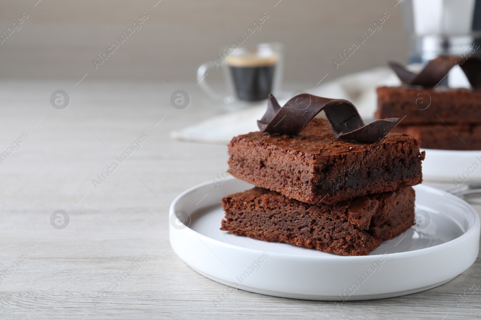 Photo of Delicious chocolate brownies on white wooden table. Space for text