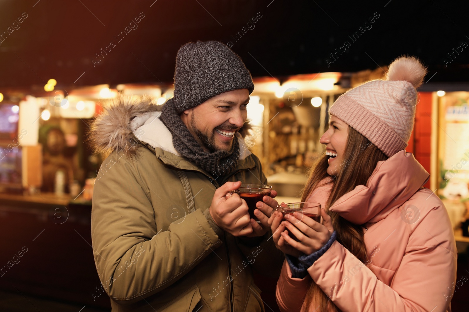 Photo of Happy couple with mulled wine at winter fair