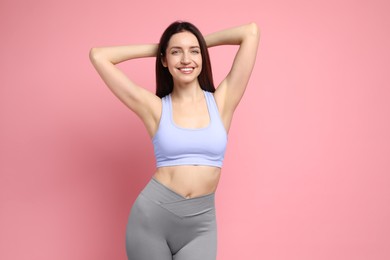 Photo of Happy young woman with slim body posing on pink background