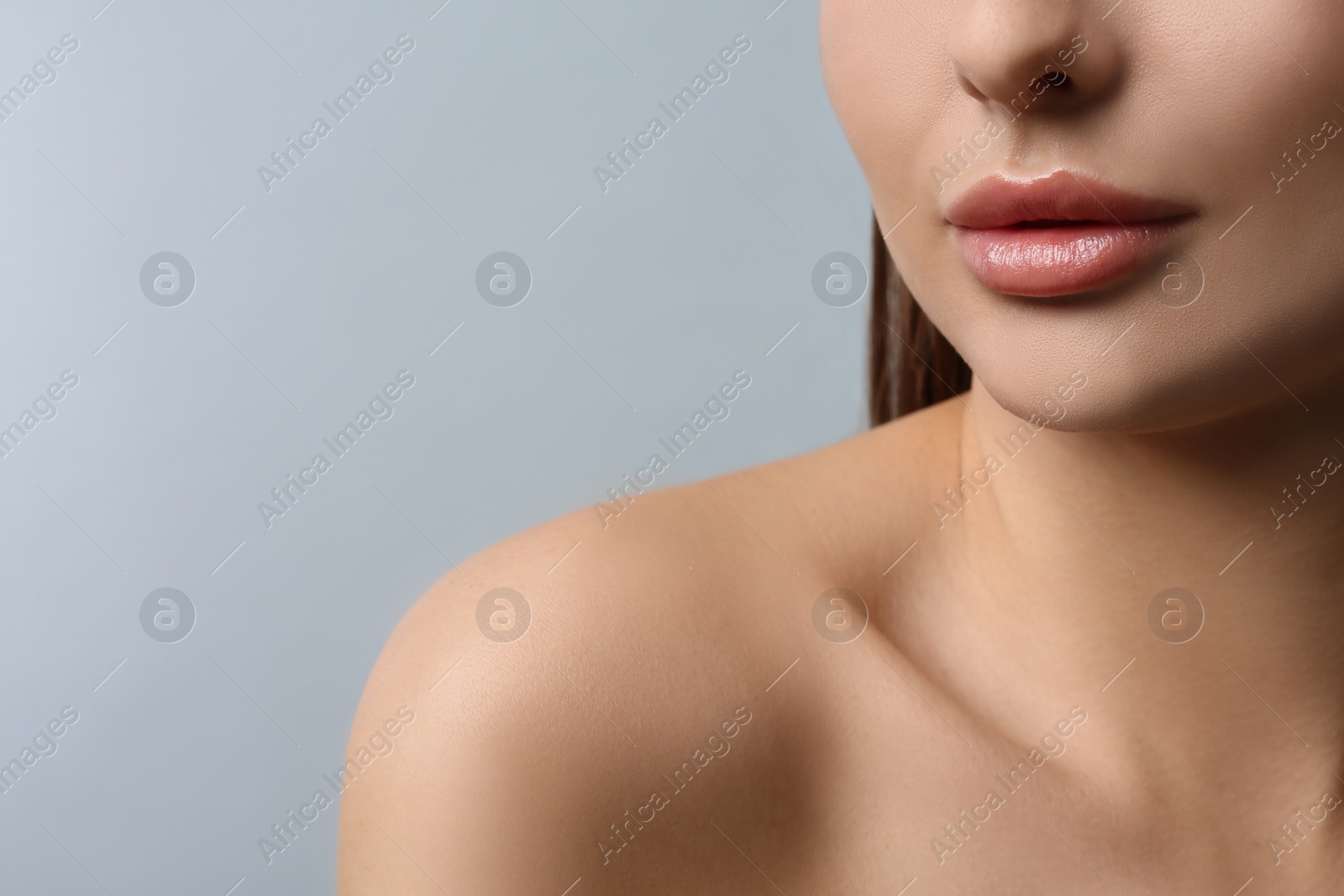 Photo of Woman with beautiful lips on light grey background, closeup. Space for text