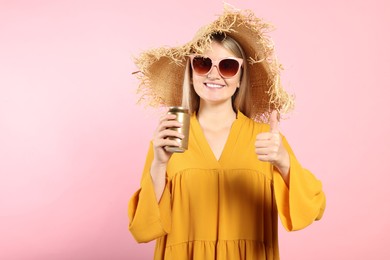 Photo of Beautiful happy woman holding beverage can and showing thumbs up on pink background