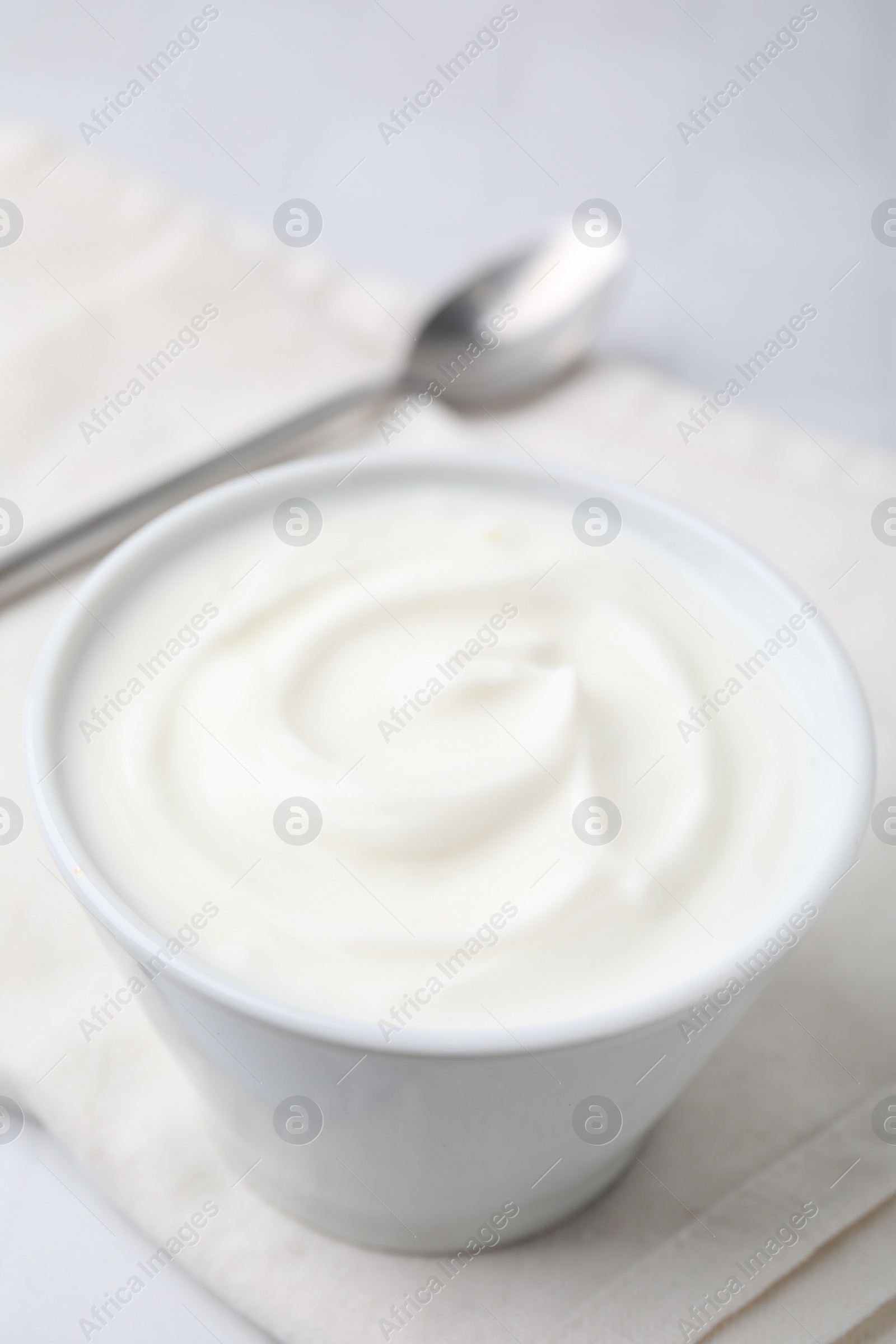 Photo of Delicious natural yogurt in bowl on table, closeup