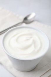 Delicious natural yogurt in bowl on table, closeup