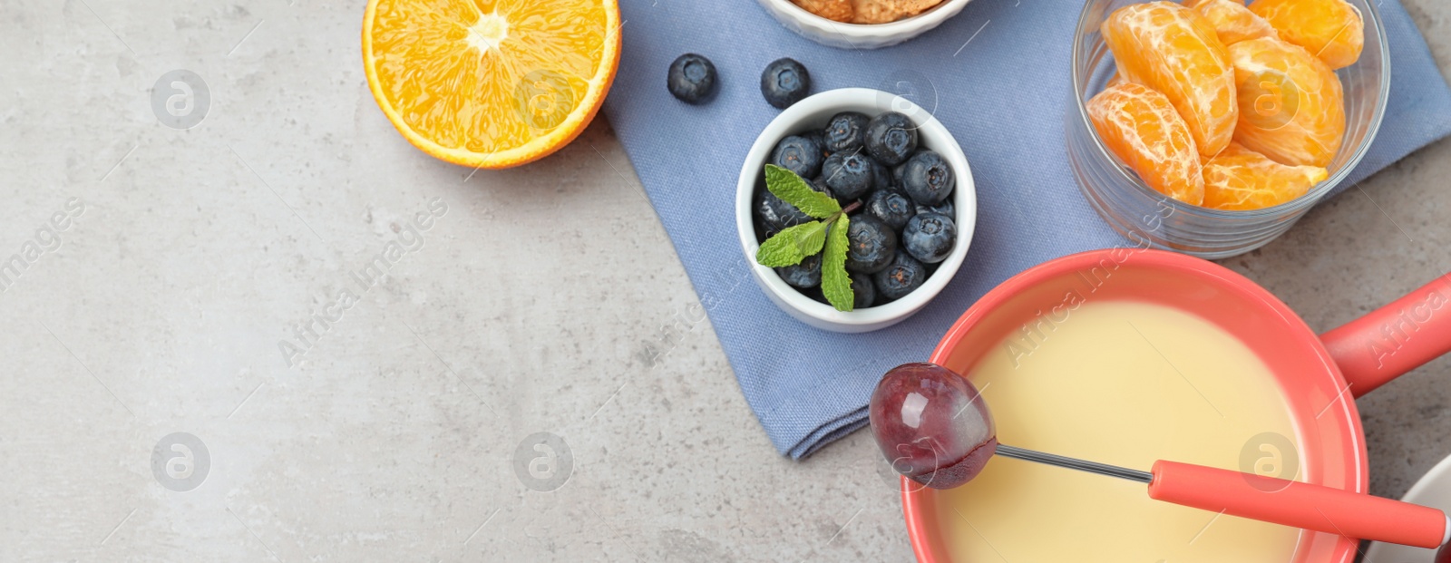 Image of Flat lay composition with white chocolate fondue on grey table, space for text. Banner design