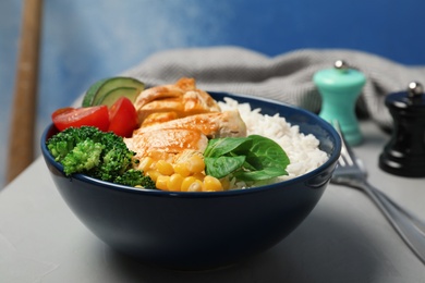 Photo of Bowl of boiled rice with vegetables and meat on table