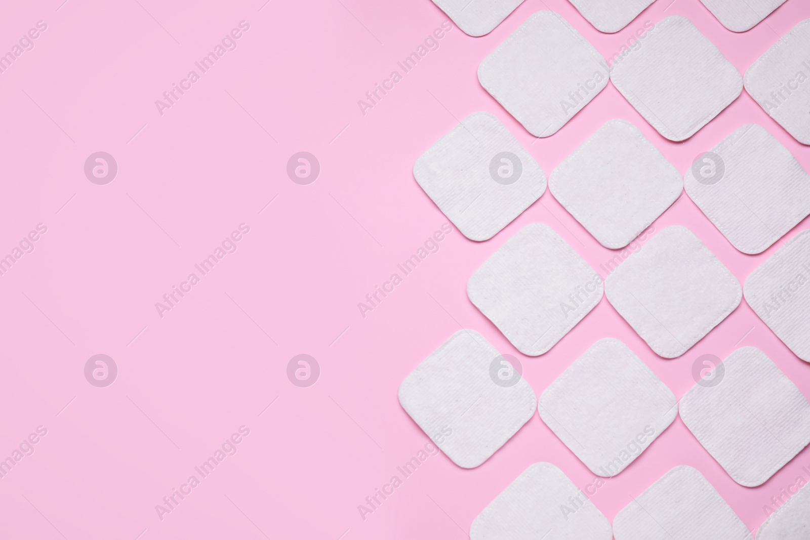 Photo of Many clean cotton pads on pink background, flat lay. Space for text