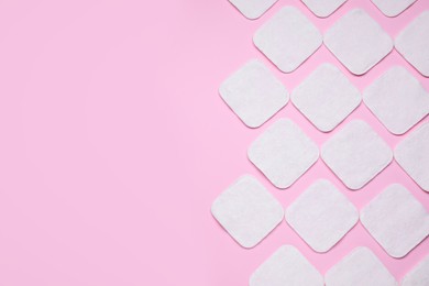 Photo of Many clean cotton pads on pink background, flat lay. Space for text