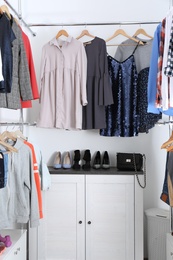 Modern dressing room with different stylish clothes and shoes