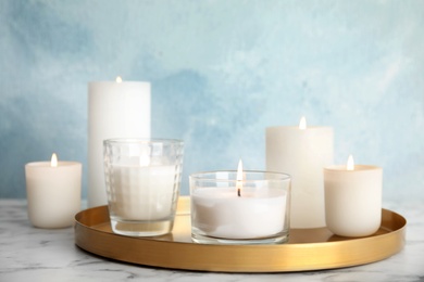 Tray with burning aromatic candles on table