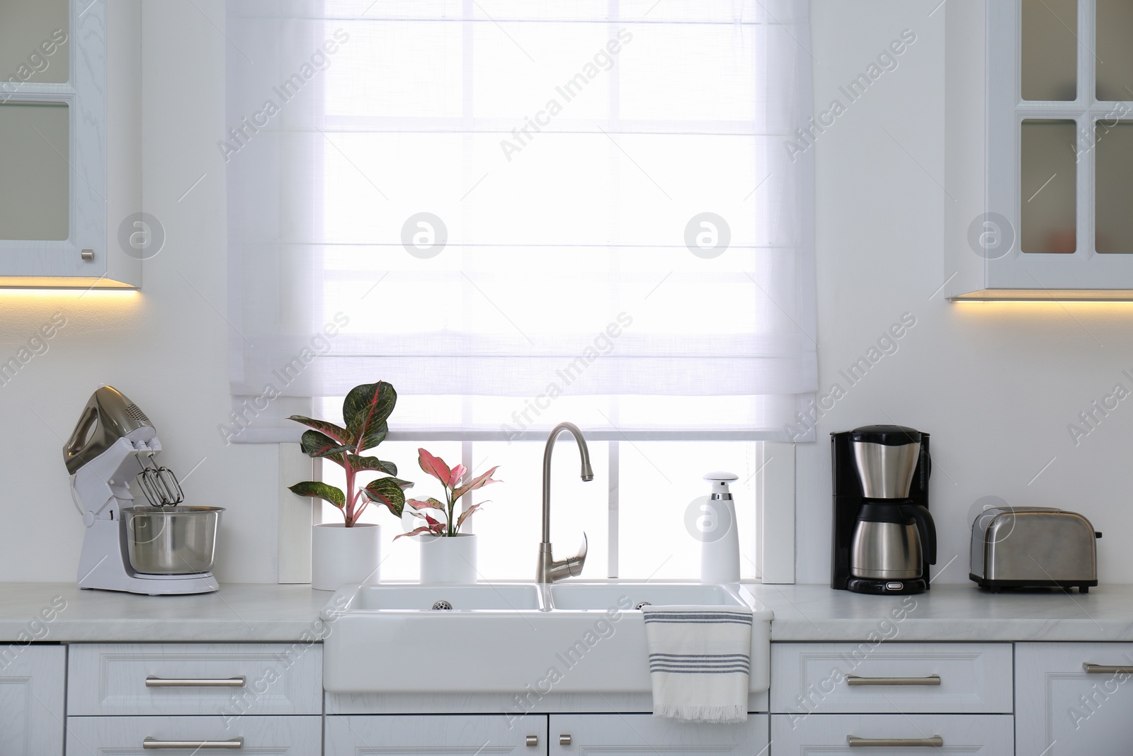 Photo of Modern toaster and household appliances on counter in kitchen