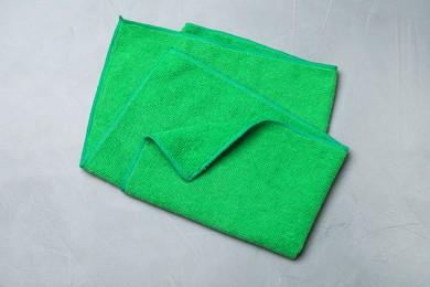 Green microfiber cloth on light grey table, top view