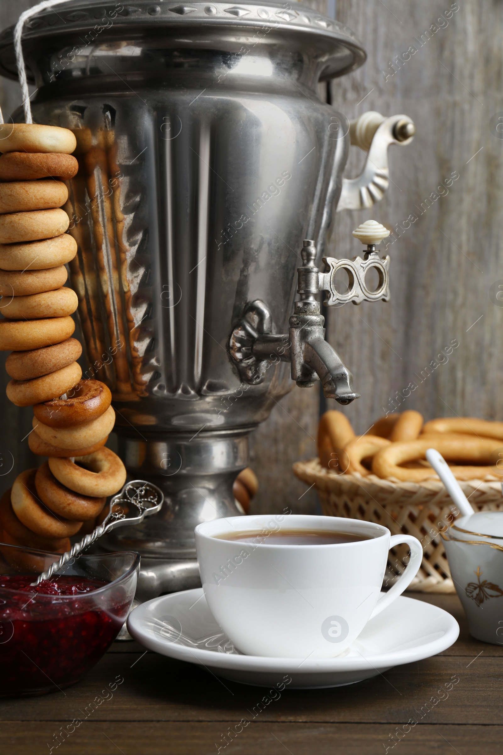 Photo of Composition with hot tea and delicious ring shaped Sushki (dry bagels) on wooden table