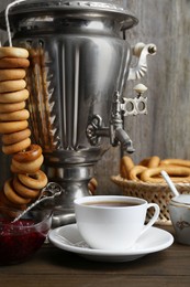 Composition with hot tea and delicious ring shaped Sushki (dry bagels) on wooden table