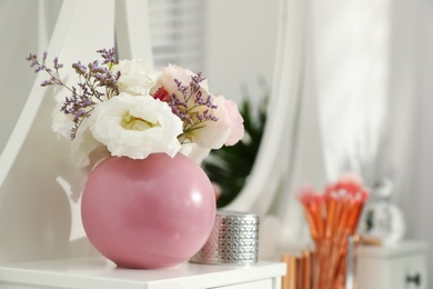 Vase with flowers on table in stylish room interior