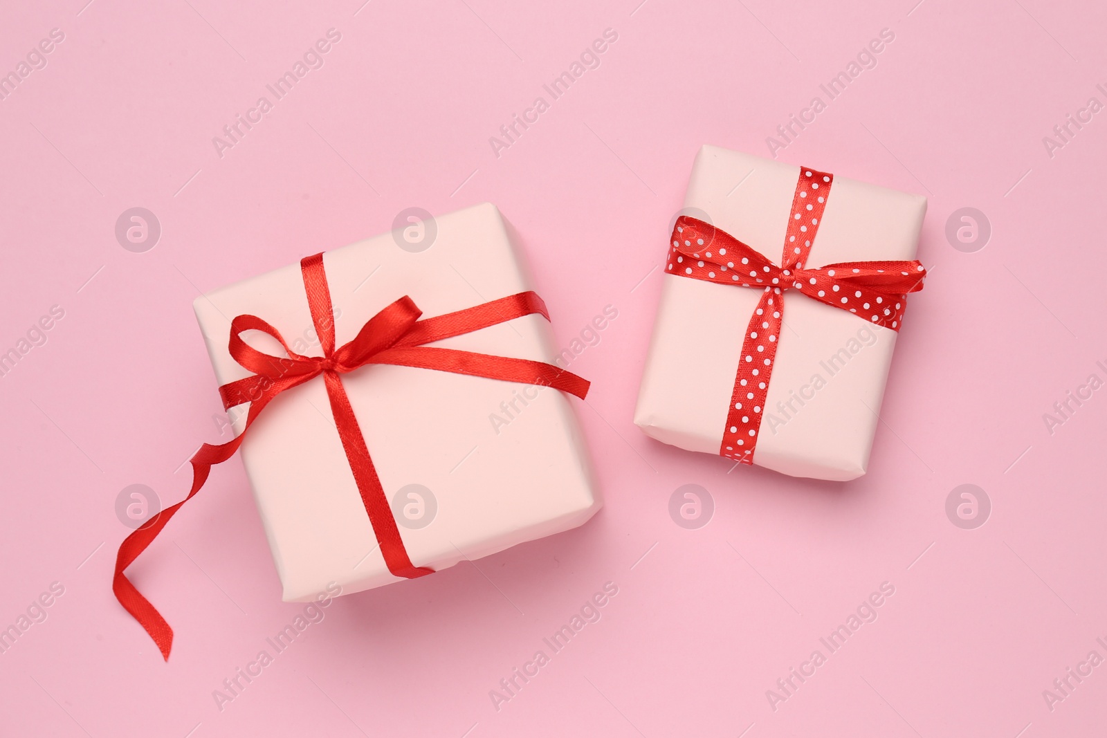 Photo of Beautiful gift boxes on pink background, flat lay