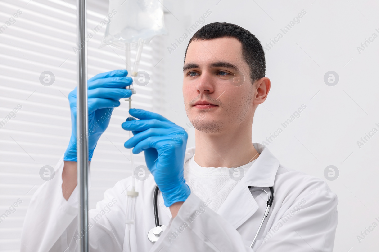 Photo of Doctor setting up IV drip in hospital