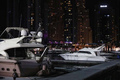 Photo of DUBAI, UNITED ARAB EMIRATES - NOVEMBER 03, 2018: Pier with luxury yachts at night