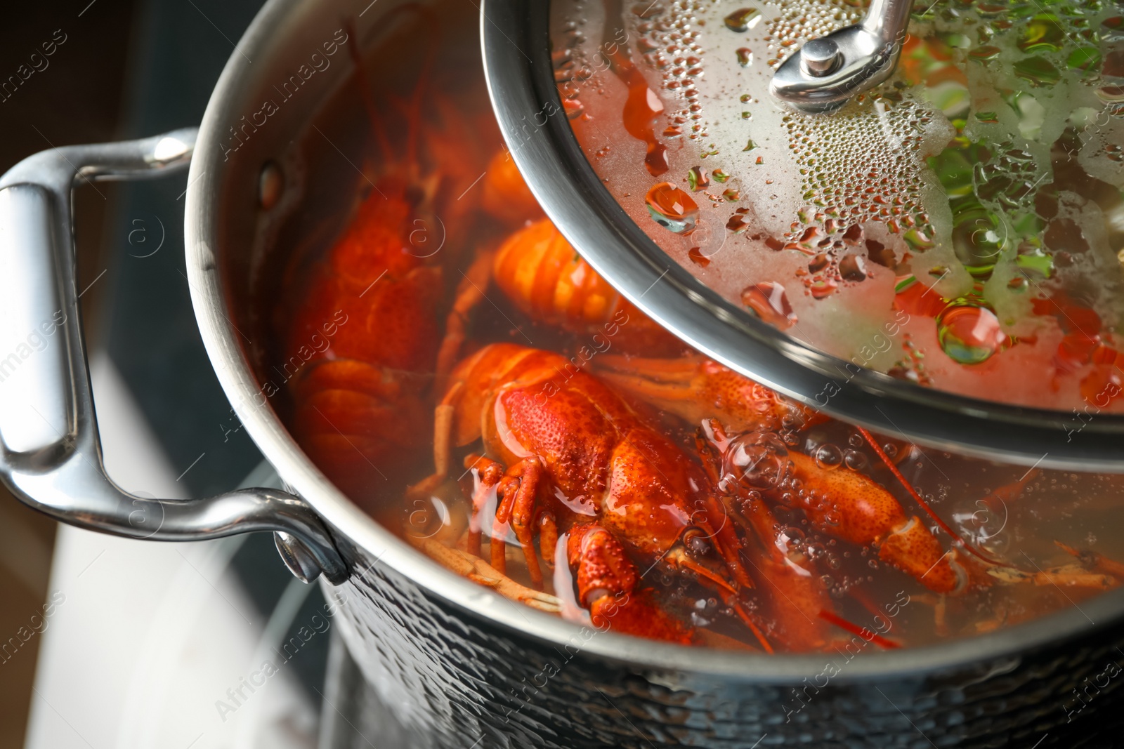 Photo of Fresh delicious crayfishes in boiling water, closeup