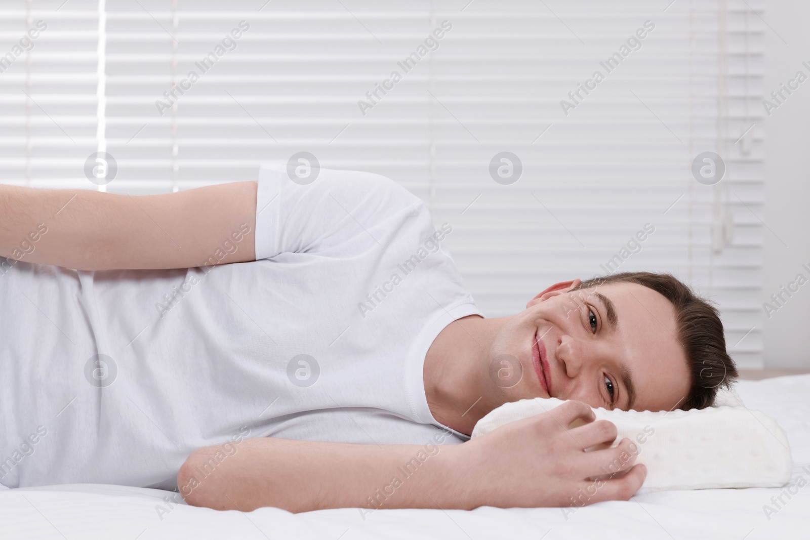 Photo of Man lying on orthopedic pillow at home