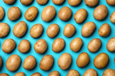 Photo of Raw fresh organic potatoes on blue background, flat lay