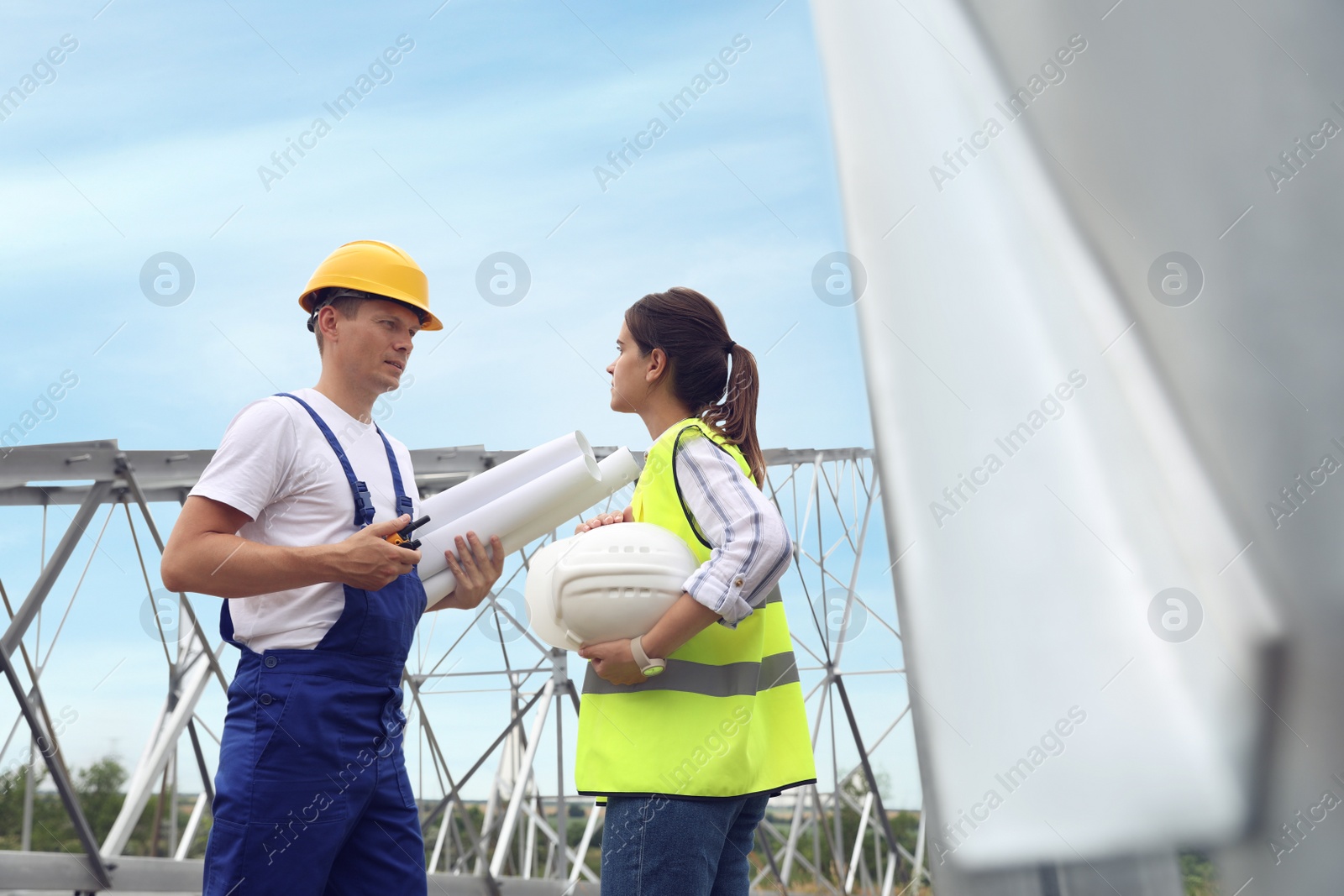 Photo of Professional engineers working on installation of electrical substation outdoors