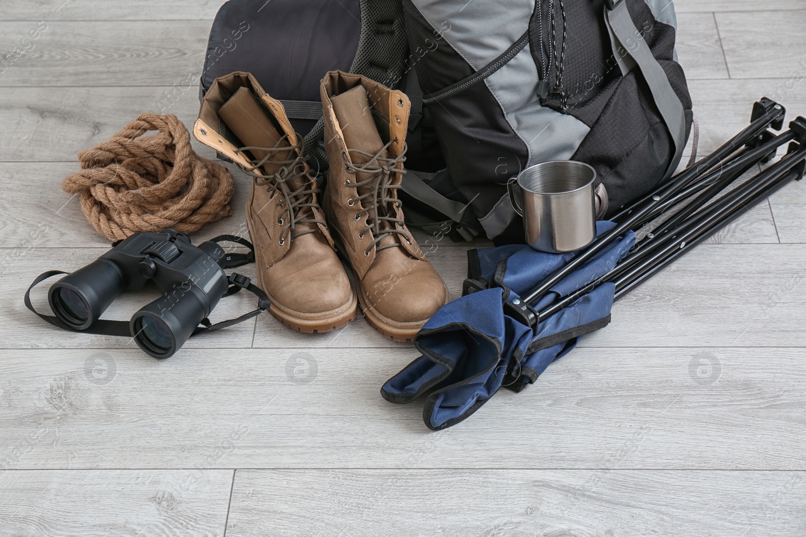 Photo of Set of camping equipment with sleeping bag on wooden floor