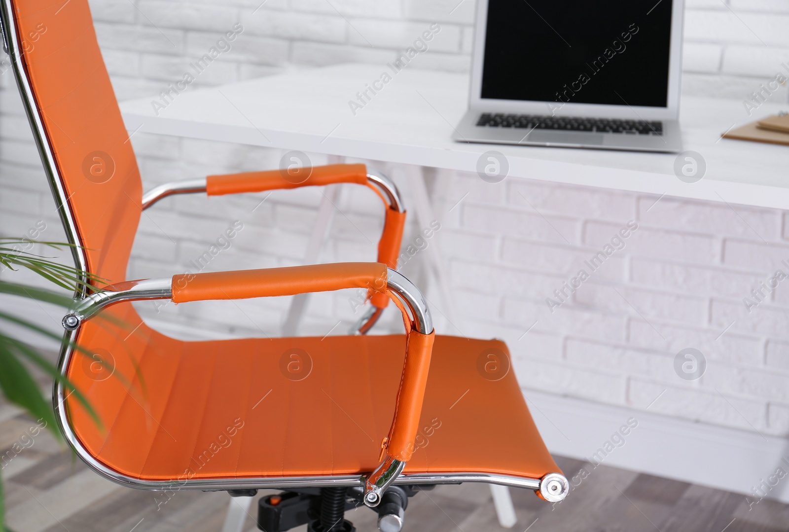 Photo of Comfortable workplace with office chair and wooden table, closeup