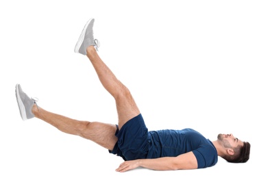 Handsome young man in sportswear doing scissors exercise on white background