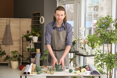 Photo of Male florist creating floral composition at workplace
