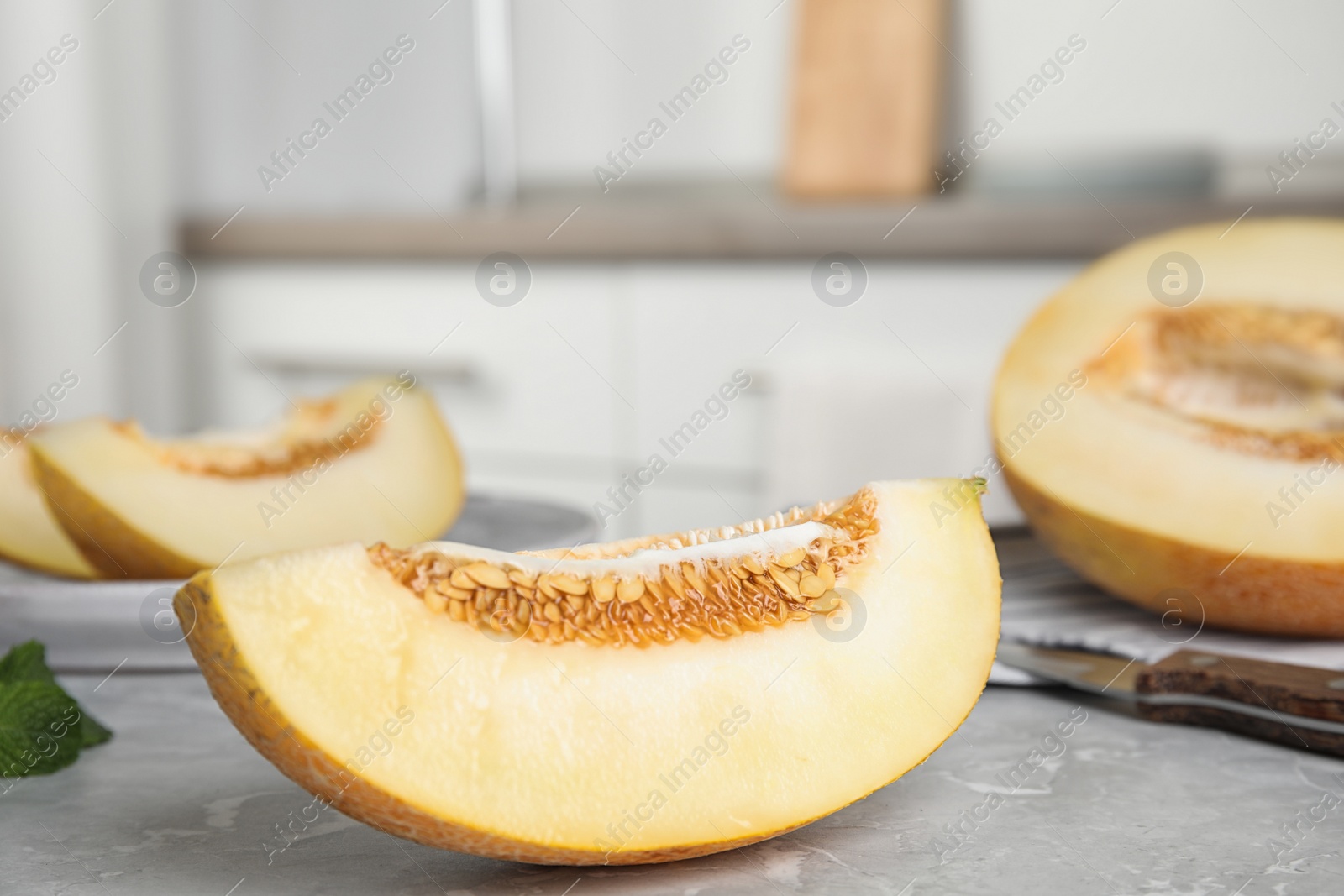 Photo of Tasty cut ripe melon on grey marble table