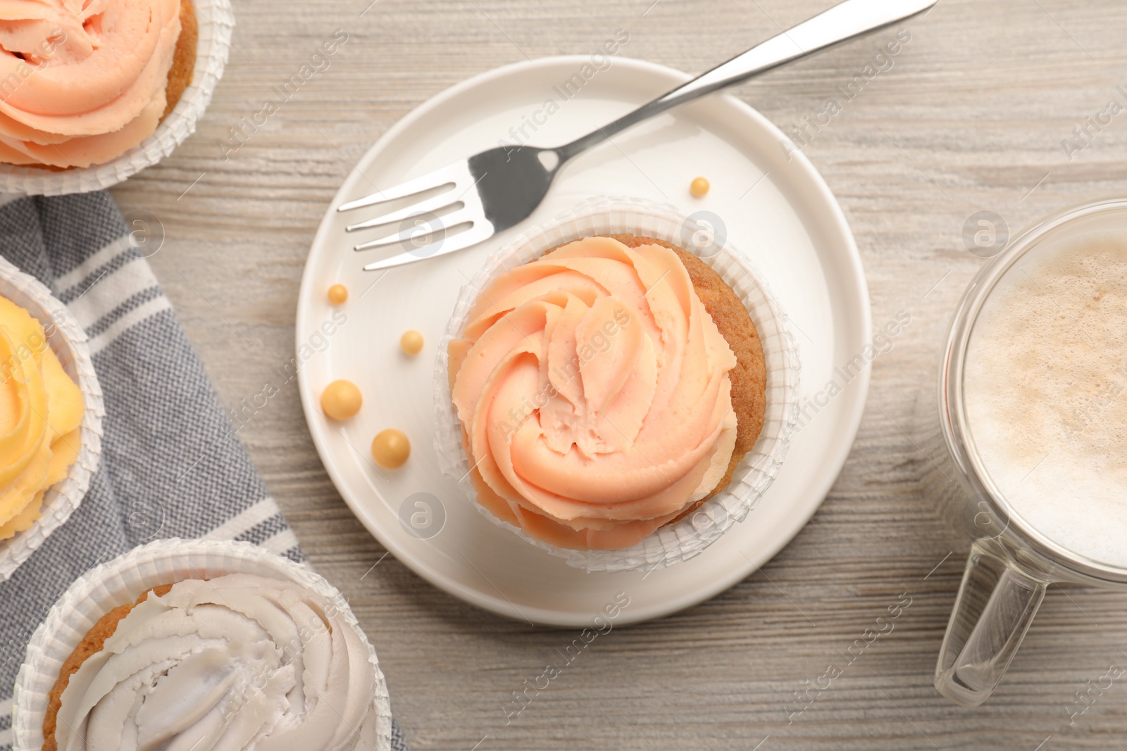 Photo of Tasty cupcakes served on wooden table, flat lay