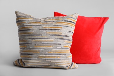 Photo of Different stylish soft pillows on grey background