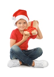 Cute little child in Santa hat with Christmas gift on white background
