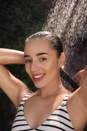 Woman washing hair in outdoor shower on summer day, closeup