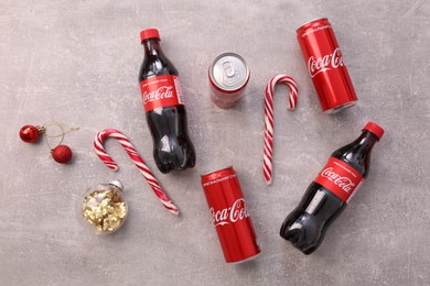 Photo of MYKOLAIV, UKRAINE - JANUARY 13, 2021: Flat lay composition with Coca-Cola cans and bottles on floor