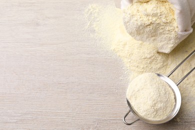 Sieve with quinoa flour on wooden table, top view. Space for text